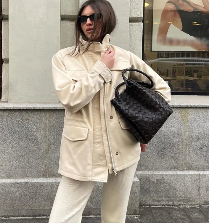 A woman wearing a stand collar waist-cinching jacket, styled for a casual outing.