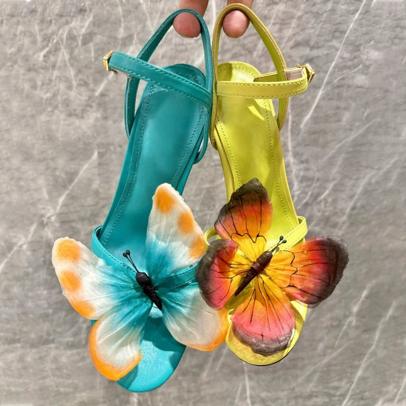 Statement colourful butterfly outdoor dress sandal for a wedding or gala event on a textured surface