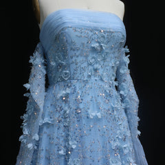  Blue evening gown with floral and beaded details on a mannequin against a black background