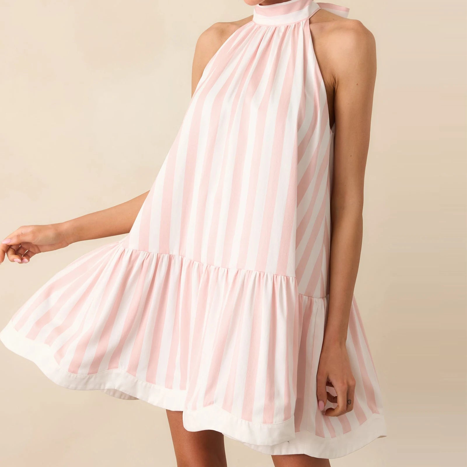 A woman modeling a striped cold-shoulder mini tank dress.