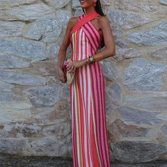   Woman in striped halter midi dress with open back against a stone wall.