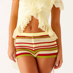 A woman modeling a pair of striped knit shorts with an elastic waist.
