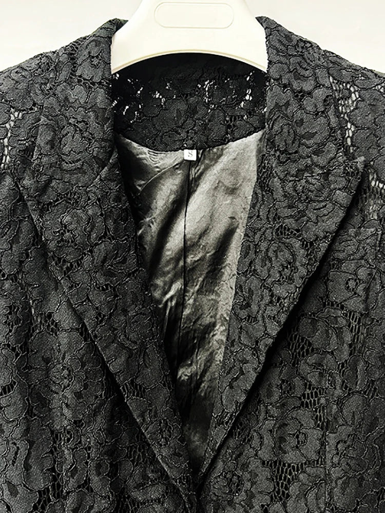 Black lace garment with satin lining on a hanger