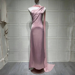 Pink evening gown on a mannequin against a white paneled wall.