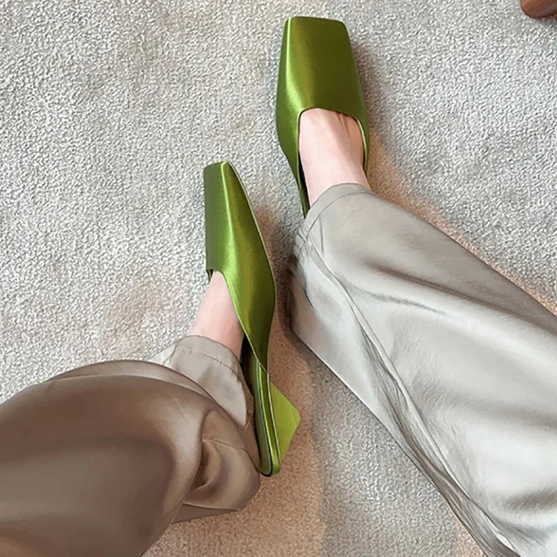 Vibrant green summer wedge heel slides on beige carpet