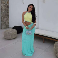 Woman in a summer vacation coastal party women’s set in green with textured knit, standing in a modern indoor setting.