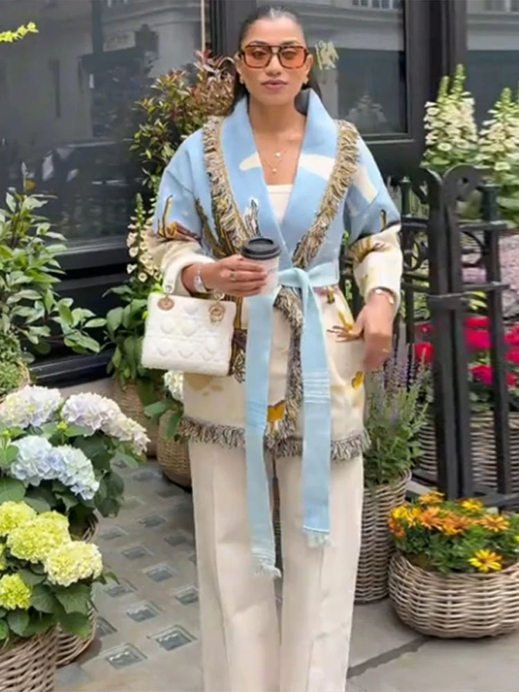 Detail-focused view capturing the tassel edge hem and printed motifs on the light blue cardigan, adding movement and texture to the look.
