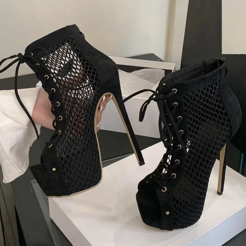 Black mesh high-heeled shoes on a white platform with a blurred background
