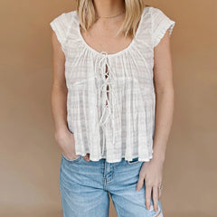 A woman modeling a tie-front smocked crop top.