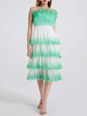 A close-up of the tiered ruffle and spaghetti strap detail on the dress.