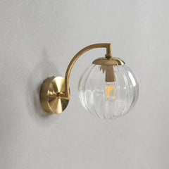 A modern transparent LED colour glass pendant light fixture mounted on a wall.