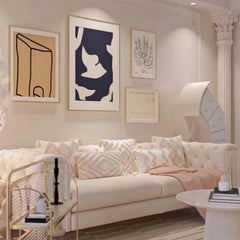 “Cream fleece velvet sofa styled with throw and pillows under wall art”