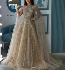 A woman wearing an elegant turquoise cape sleeve evening gown for a formal event.
