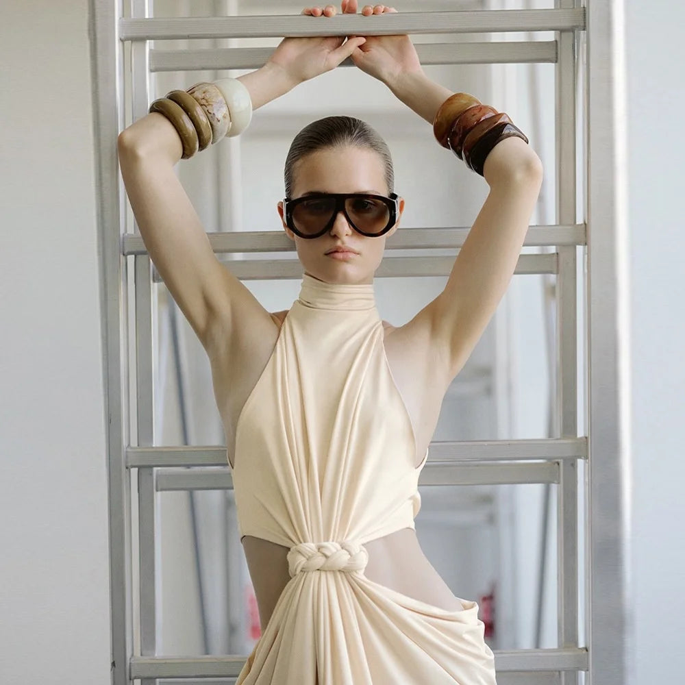 Floor-length column gown with sculpted pleats and clean high neckline