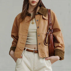 Person wearing a brown jacket with a leather bag on a plain background