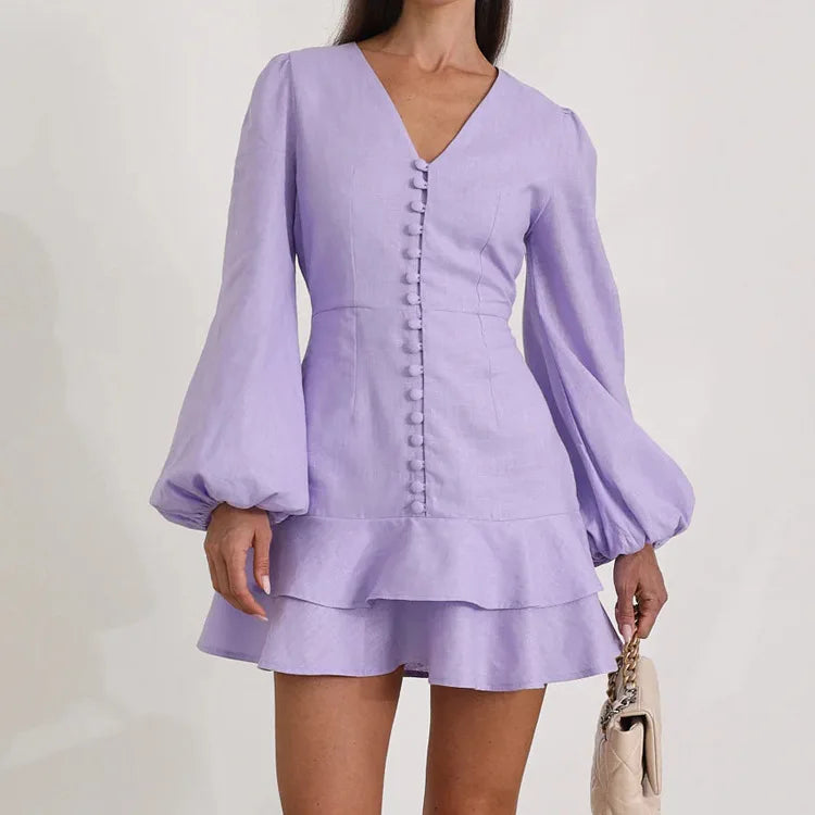 V-neck long sleeve purple dress styled with a beige clutch