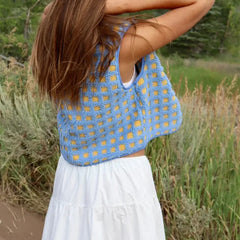 Woman wearing a blue and yellow patterned top outdoors