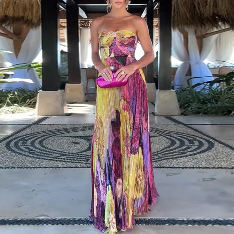 Colorful floral maxi dress styled with pink clutch in tropical resort setting