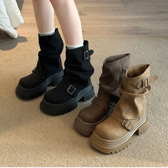 Black platform ankle boots with belt buckle on carpet