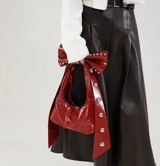 Rivet-accented red bow handbag in soft PU leather