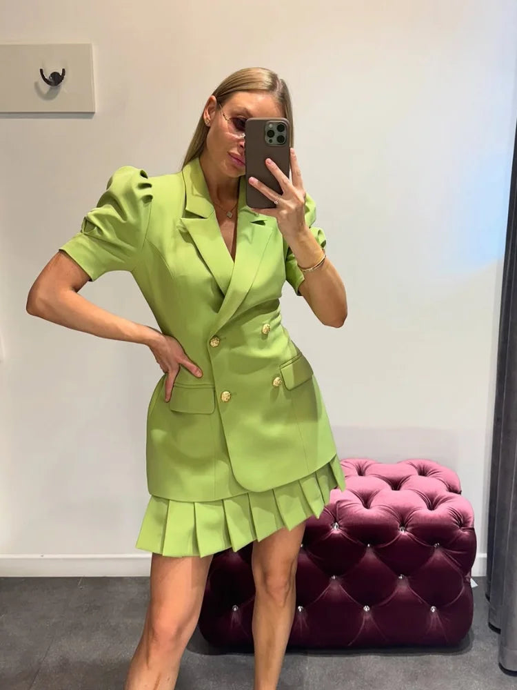 Woman taking a mirror selfie wearing a vintage-style summer outfit for city brunch or work events in a room with a pink tufted ottoman.