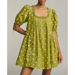 A woman modeling a vintage-inspired puff sleeve mini dress with a floral print.