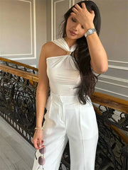 Woman in white halter knit tank standing on staircase with backless view