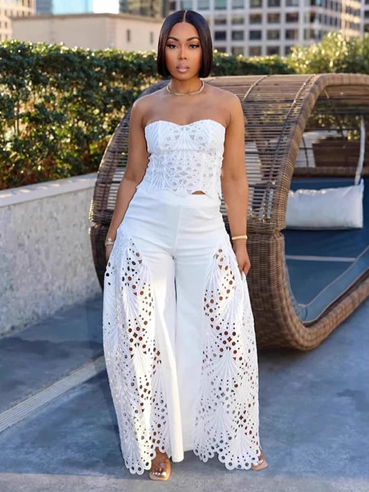 Woman wearing white strapless top with crochet panels and wide-leg pants