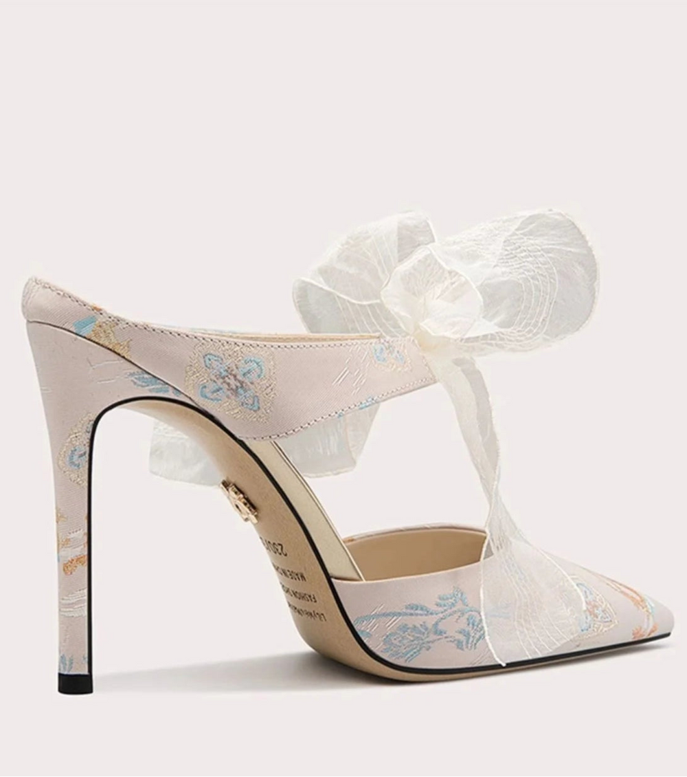 High-heeled shoe with floral design and sheer ribbon on a white background