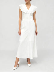 Woman wearing a white midi dress with an eyelet collar and V-neckline.