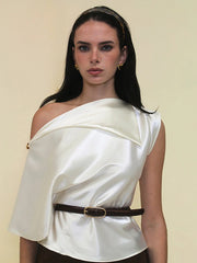 A close-up of the single button and satin fabric on the white tee.