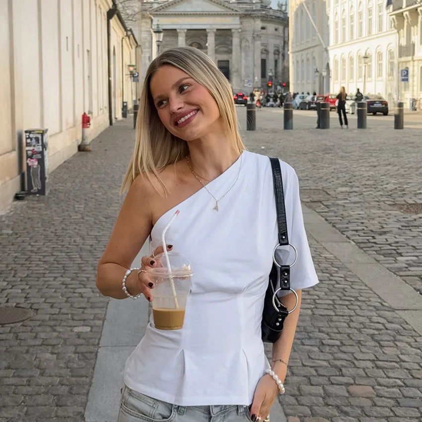 White one-shoulder top styled casually on city streets