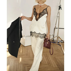 Close-up of the lace-trim V-neckline and thin straps, showing the contrast lace pattern against the smooth satin finish.