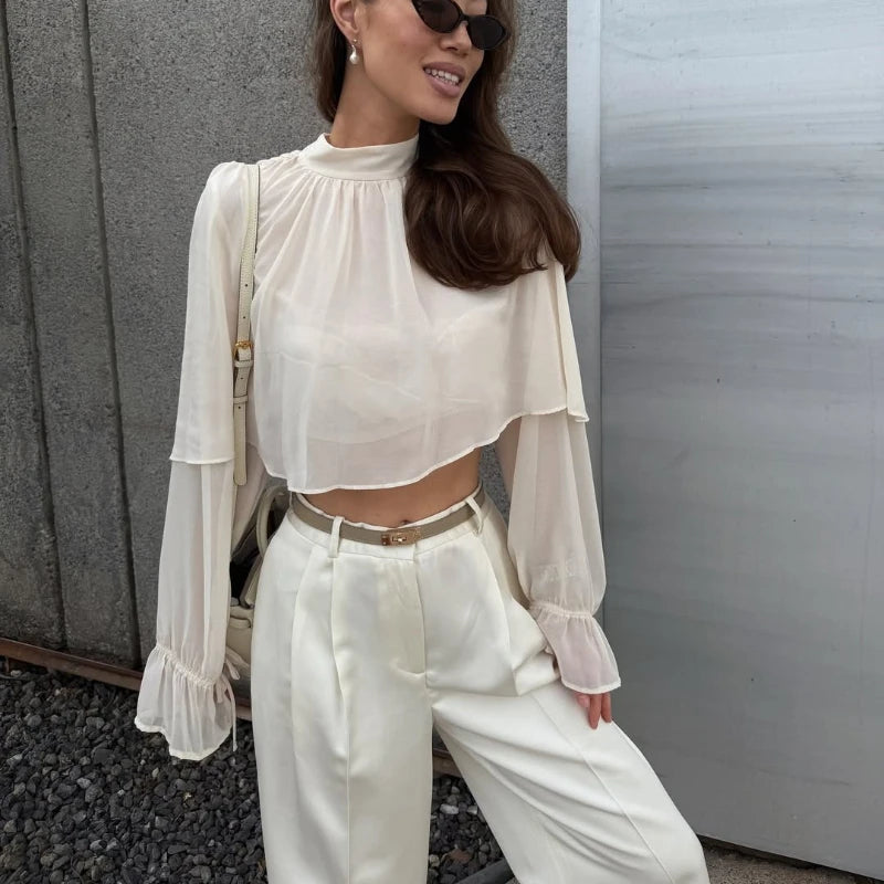 Close view of the pleated chiffon drape and airy sleeve finish, showing the lightweight texture and fluid movement of the overlay.