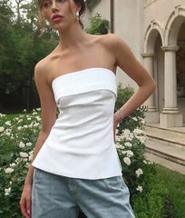 Woman wearing white strapless bandeau top with denim