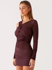 Woman wearing a burgundy dress with long sleeves on a white background