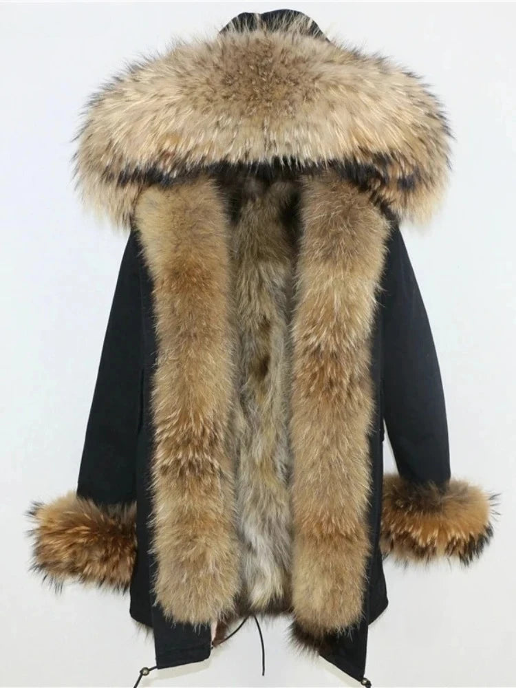 Three-quarter view shows the long hem coverage, clean side line, and pocket placement with the hood volume draping down the front.