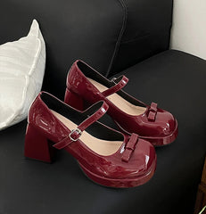 Glossy red Mary Jane shoes with strap and bow detail