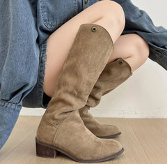 Women’s retro suede boots styled on wooden floor