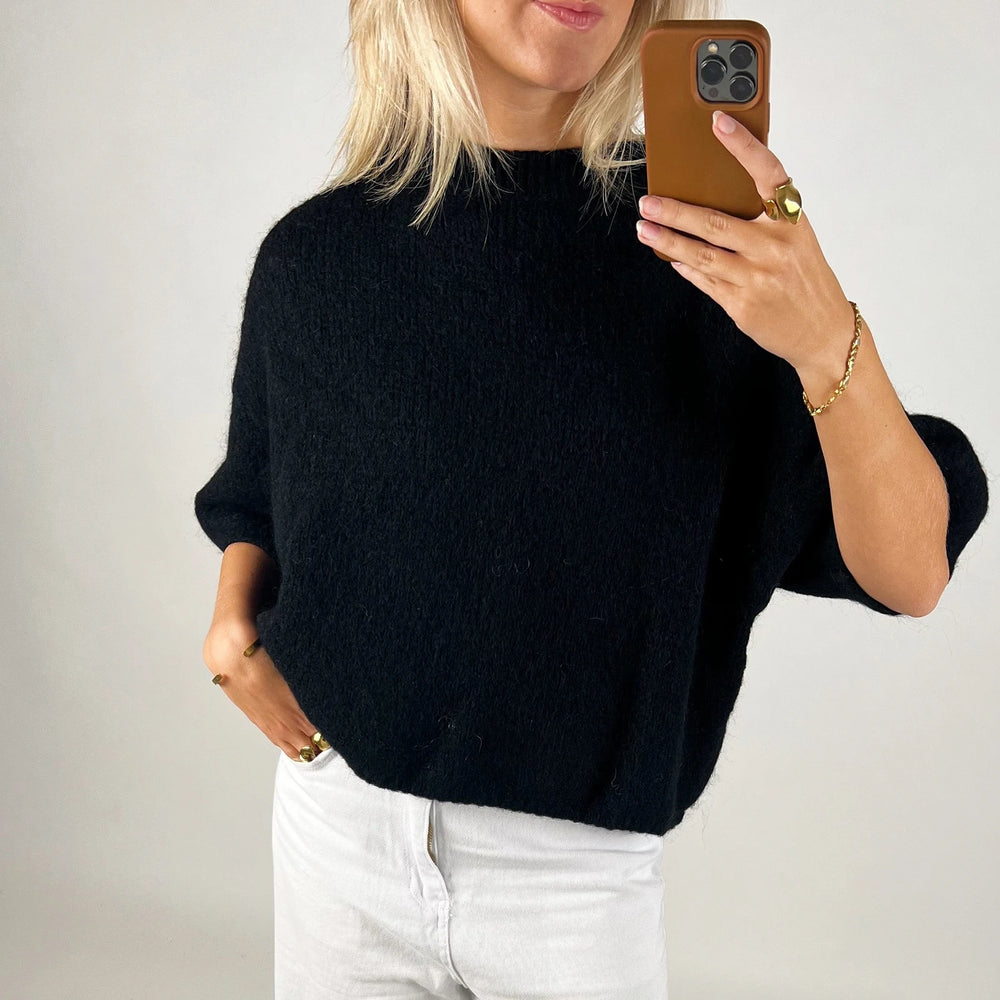 A women's regular-fit knit shirt styled with jeans.
