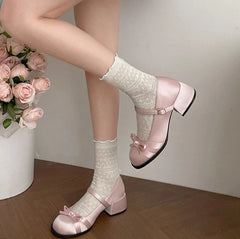 Close-up of square toe and satin bow on pink women’s pumps