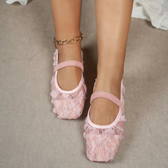 Pink lace shoes worn by a person on a neutral background