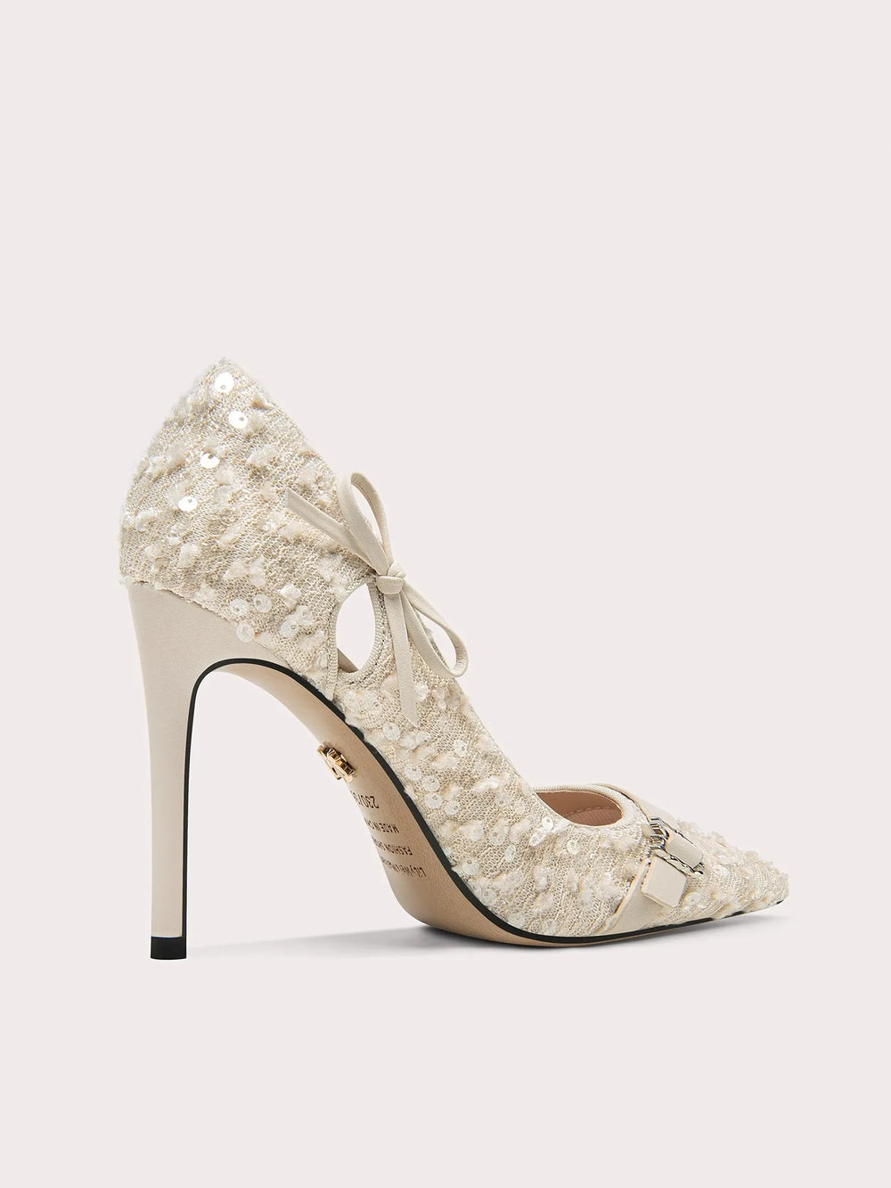 Elegant high-heeled shoe with lace detailing and bow on a light gray background
