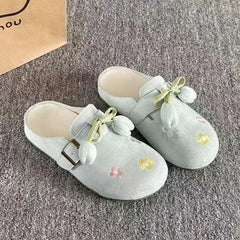 Side angle of green faux suede closed toe mules with floral detail