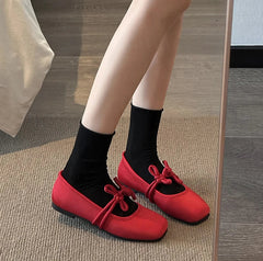 Red satin ballet flats with square toe styled with socks