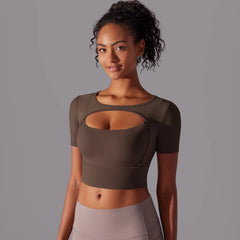 Woman wearing a brown mesh gym training shirt styled with leggings for a sporty look on a gray background