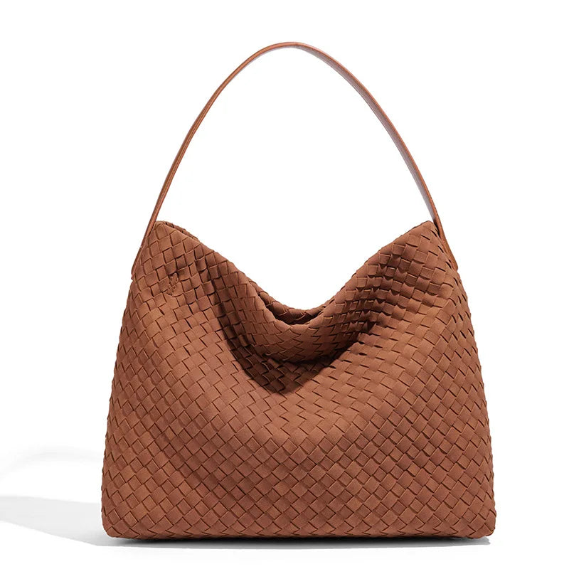 Shoulder strap and top opening detail on a woven-texture tote bag