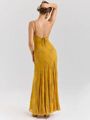 Woman wearing a yellow dress with floral patterns on a white background