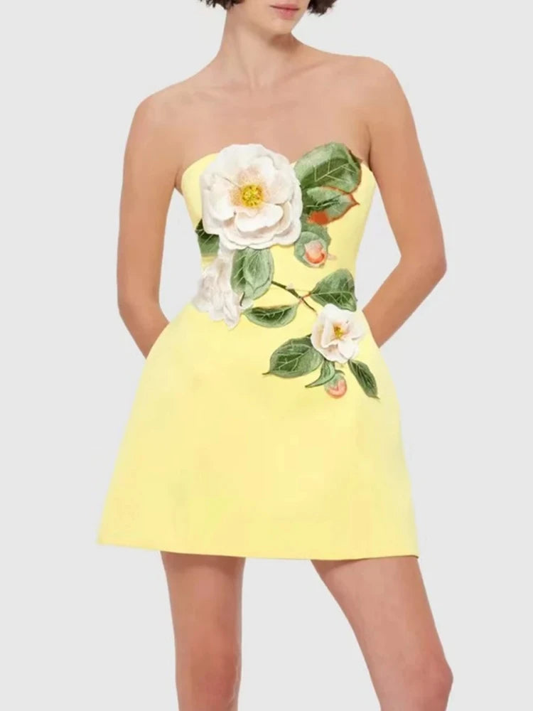 Yellow strapless mini dress with white floral embroidery on a plain background
