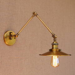 A brass adjustable swing arm wall light sconce with a gold finish and a shade, mounted on a wall lighting bulb.